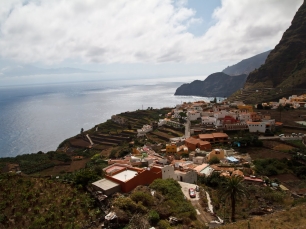 Vista de Agulo desde las laderas: el casco y las parcelas ocupan el borde entre las alturas y el océano.