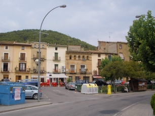 La plaza de Ayerbe y las casas de la villa, con una elevación arbolada al fondo. La imagen sitúa el núcleo urbano en el paisaje de cerros y llanos.