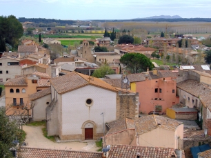 Vista elevada del núcleo de Cervià de Ter, con la iglesia de Sant Genís y la llanura agrícola al fondo; permite apreciar el caserío en relación con el paisaje que lo rodea.