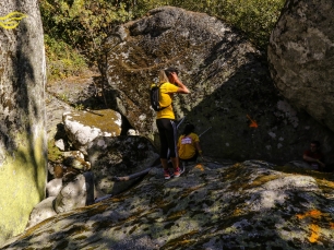Un corredor atraviesa un conjunto de grandes bloques rocosos en Oímbra. La escena sitúa el paisaje del municipio sin atribuir una litología concreta a las rocas visibles.