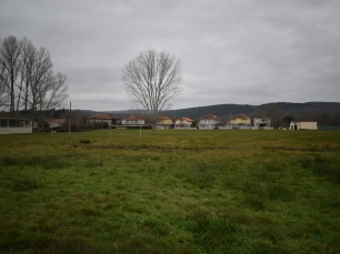 El campo de fútbol de Lodoselo, con el caserío y las lomas del entorno de Sarreaus al fondo.