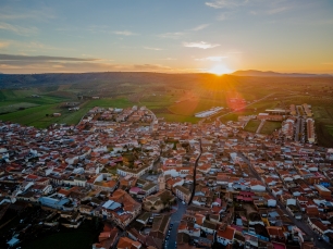 Belvís de la Jara, visto desde el aire al atardecer. El casco urbano queda enmarcado por el paisaje que desciende hacia el norte.