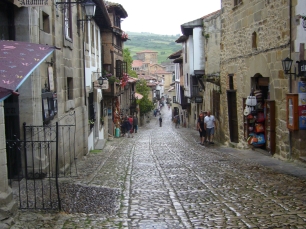 Una calle de Santillana del Mar, con las laderas al fondo; Altamira conserva una presencia humana muy anterior al núcleo histórico de la villa.