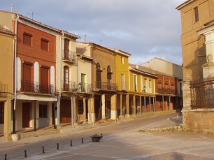 Una calle porticada de Villalón de Campos, con fachadas de ladrillo y soportales que dan forma a este espacio urbano de Tierra de Campos.