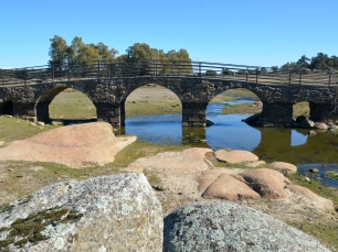 El puente sobre el río Salor, en el entorno de Torreorgaz. La roca visible junto al cauce forma parte del paisaje de la penillanura.