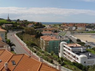 Panorámica de Comillas junto a la costa cantábrica: el núcleo urbano, las lomas y el mar en un mismo paisaje.