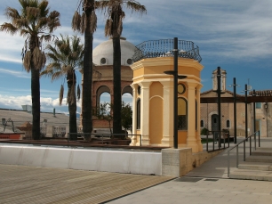 Espacio público de Caldes de Malavella, con palmeras, una lámina de agua y construcciones de perfiles distintos. Las aguas termales contribuyeron al origen del núcleo urbano y a su posterior expansión balnearia.