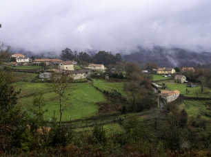 Vista del lugar de Chacente, en O Campo, Campo Lameiro, entre prados, viviendas y laderas.