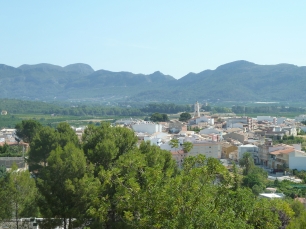 Vista de Ròtova con el núcleo urbano y la iglesia de Sant Bartomeu enmarcados por el relieve montañoso.
