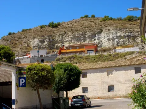 Construcciones de Zuera junto a una ladera con capas claras visibles: el relieve también forma parte del paisaje urbano.