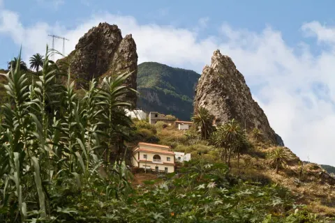 Los Roques Pedro y Petra se alzan junto a las viviendas y las parcelas de Agulo, dentro del paisaje que une el valle con la costa.