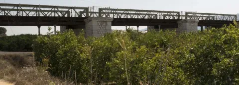 El Pont de Fortaleny cruza el Xúquer y enlaza las orillas mediante su estructura de hierro.