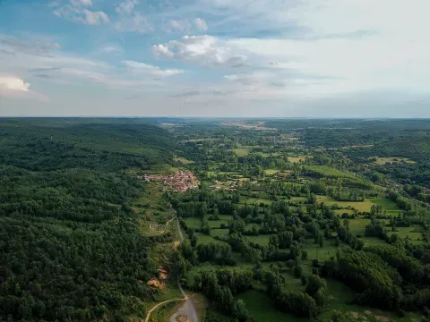 Vista aérea del valle del Torío hacia el sur, con Manzaneda de Torío entre arbolado y terrenos abiertos. La perspectiva ayuda a reconocer el valle y los relieves que lo acompañan.