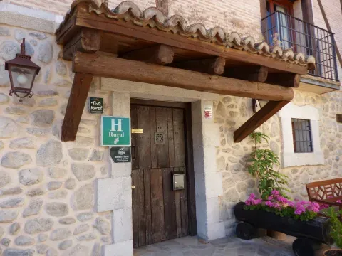 Una casa de Rascafría muestra la escala doméstica de la arquitectura popular serrana, entre la calle del pueblo y el paisaje de montaña.