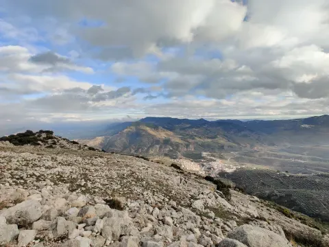El roquedo de Cerro Gordo ocupa el primer plano y Bélmez aparece al fondo. La vista reúne el relieve y el núcleo en un mismo paisaje.