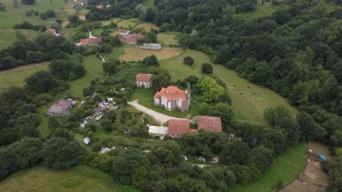 Vista aérea del conjunto de iglesia y edificaciones de Penilla, integrado en el paisaje rural de Villafufre.
