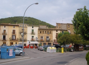 La plaza de Ayerbe y las casas de la villa, con una elevación arbolada al fondo. La imagen sitúa el núcleo urbano en el paisaje de cerros y llanos.
