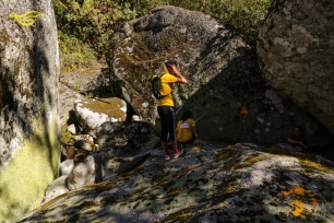 Un corredor atraviesa un conjunto de grandes bloques rocosos en Oímbra. La escena sitúa el paisaje del municipio sin atribuir una litología concreta a las rocas visibles.