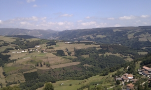 Una vista de Allande entre laderas, prados y sierras. El relieve que aparece en el horizonte separa las aguas entre las cuencas del Navia y del Narcea.