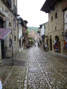 Una calle de Santillana del Mar, con las laderas al fondo; Altamira conserva una presencia humana muy anterior al núcleo histórico de la villa.