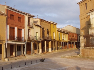 Una calle porticada de Villalón de Campos, con fachadas de ladrillo y soportales que dan forma a este espacio urbano de Tierra de Campos.