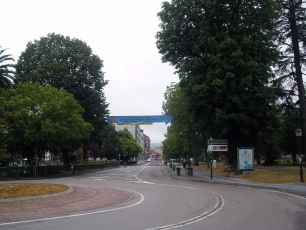Una avenida arbolada de Grado muestra el tejido urbano de la villa y el paisaje que la rodea.