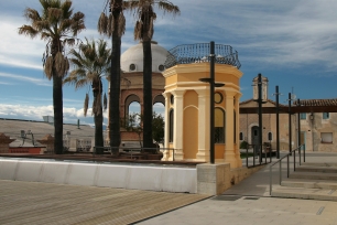 Espacio público de Caldes de Malavella, con palmeras, una lámina de agua y construcciones de perfiles distintos. Las aguas termales contribuyeron al origen del núcleo urbano y a su posterior expansión balnearia.