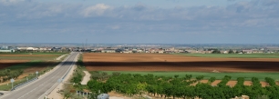 Casas de Juan Núñez desde la CM-3209, con los campos abiertos que rodean el casco.