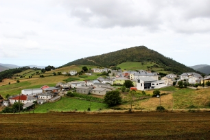 Villayón se extiende bajo una loma, con el caserío en primer plano y las sierras como telón del concejo.