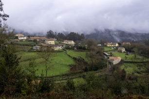 Vista del lugar de Chacente, en O Campo, Campo Lameiro, entre prados, viviendas y laderas.